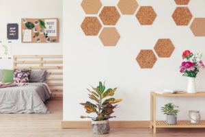 DIY Hexagon honeycomb cork on white wall in contemporary natural apartment with bedroom wooden floor and floral decor